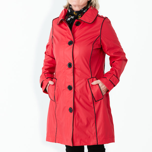 Raincoat by Pipduck in red polyurethane with piped black edging , fully lined with detachable hood.