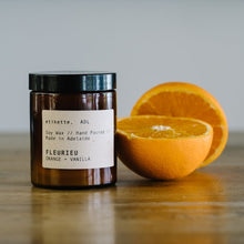 Load image into Gallery viewer, Hand poured Soy Candle in amber jar with fragrance notes of orange + vanilla.
